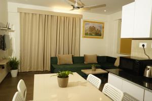 a living room with a green couch and a table at DayOne Suites Kuvempu in Bangalore