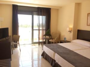 ein Hotelzimmer mit einem Bett und einem großen Fenster in der Unterkunft Hotel Adaria Vera in Vera