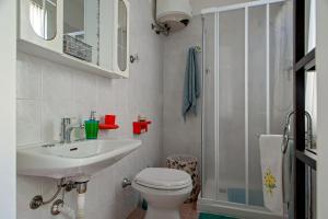 a bathroom with a toilet and a sink and a shower at Casina di Alo e Ala in Livorno