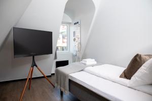 a living room with a white couch and a flat screen tv at Bob W Sentralen in Oslo