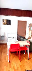 una habitación con una mesa y dos bancos rojos en B&B L'Assiolo, en Ancona