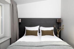 a bedroom with a large bed with a black headboard at Bob W Sentralen in Oslo