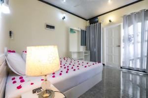 1 dormitorio con 1 cama con pétalos de rosa en Local Travel Beach Maldives en Hangnaameedhoo