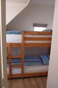 two bunk beds in a room with a staircase at Zomerhuis Toda Cambia dicht bij strand in Noordwijk aan Zee