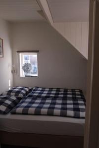 a bed in a room with a checkered mattress at Zomerhuis Toda Cambia dicht bij strand in Noordwijk aan Zee