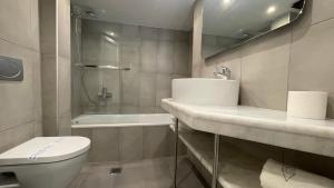 łazienka z umywalką, toaletą i wanną w obiekcie Hotel Atlanta w mieście Patras