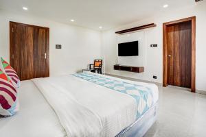 a bedroom with a large bed and a television at Sayhallo Prime Residency in Bhubaneshwar