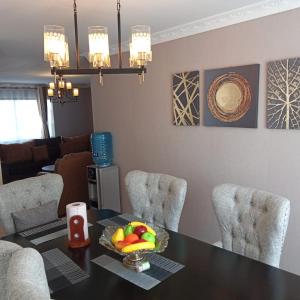 a dining room with a table with chairs and a bowl of fruit at BELLS TRIAD - FREE TRANSPORT FROM AIRPORT FOR PRE PAYMENT BOOKINGs in Nairobi