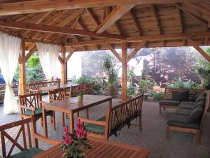 a wooden pavilion with tables and chairs and a couch at Aviator in Pabianice