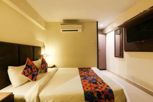 a hotel room with a bed and a tv at FabHotel West Inn in Mumbai