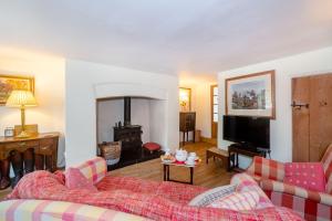 a living room with a couch and a tv at 4 Bishops Cottages in Minehead