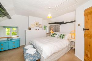 a bedroom with a large bed and a blue cabinet at 4 Bishops Cottages in Minehead