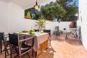 eine Terrasse mit einem Tisch und Stühlen auf einem Backsteinboden in der Unterkunft Arbocers in Ciutadella