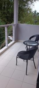 a patio with a table and a chair on a porch at RIVERSIDE PALM INN SG LEMBING in Sungai Lembing