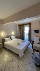 a bedroom with a large bed and a window at Hotel Atlanta in Patra