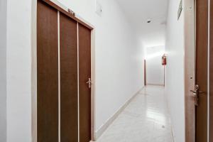 - un couloir avec deux portes en bois et du carrelage dans l'établissement Super Collection O Sayhallo Hillside Magnum, à Khandagiri