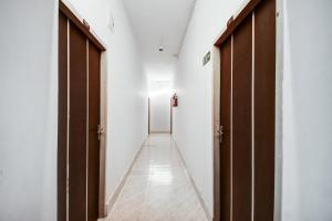 a corridor with two brown doors and a white wall at Super Collection O Sayhallo Hillside Magnum in Khandagiri
