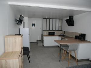 a kitchen with a refrigerator and a table and chairs at Studio Indépendant, au calme. in La Roche-sur-Yon