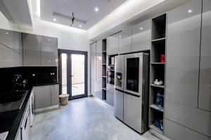 uma cozinha com electrodomésticos de aço inoxidável e armários a preto e branco em Villetta di lusso in Tunisia em Tunes