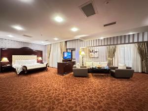 a large hotel room with a bed and a television at Modern Hotel in Baku