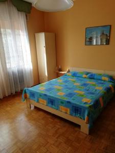 een slaapkamer met een bed met een blauw dekbed bij Alloggio Cristina in Valdobbiadene