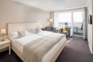 a hotel room with a large bed and a balcony at Akzent Hotel Dorn in Büsum