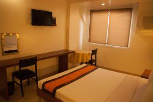 Postel nebo postele na pokoji v ubytování M Suites Hotel
