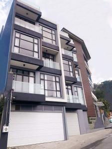 een groot appartementencomplex met een witte garage bij UPHILL HOTEL BAGUIO in Baguio