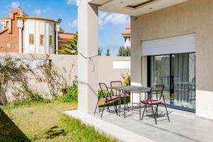 um pátio com uma mesa e cadeiras ao lado de uma casa em Villetta di lusso in Tunisia em Tunes