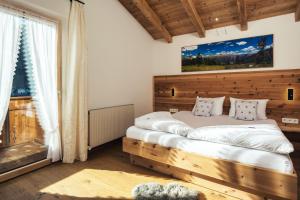 a bedroom with a wooden bed and a large window at Apart Piz Lad in Nauders