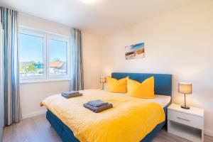 a bedroom with a bed with yellow sheets and a window at Kehrwieder Zinnowitz in Zinnowitz