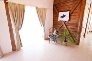 Zimmer mit einem Fenster, einem Stuhl und einer Pflanze in der Unterkunft ニア・ヤコモ 