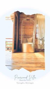 a bird cage in a room with a wooden floor at Rancho Oco Pinewood Villa with Swimming Pool in Nasugbu