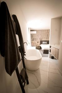 a bathroom with a bath tub and a bedroom at Vins de Dagne in Montlaur