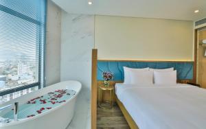 a hotel room with a bed and a bath tub at San Marino Boutique Danang in Da Nang