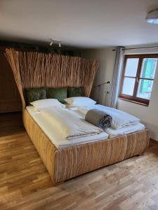 - un grand lit avec une tête de lit en bois dans une chambre dans l'établissement Hotel & Restaurant Sonnenhöfle, à Sommerhausen