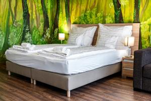 a bed with white sheets and pillows in a bedroom at Ózoon Hotel in Nyíregyháza