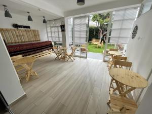 Casaroma Hostels في ليما: غرفة فيها بيانو وطاولات وكراسي
