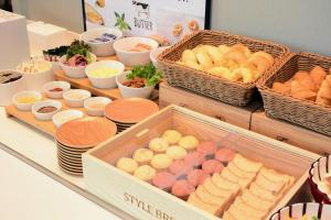 a buffet with baskets of bread and other foods at Sotetsu Fresa Inn Yodoyabashi in Osaka