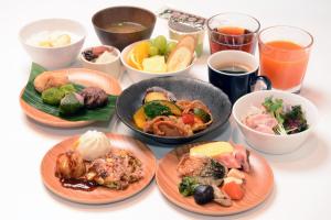 una mesa con platos de comida y tazones de comida en Sotetsu Fresa Inn Yodoyabashi en Osaka