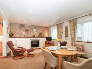 a living room with a table and chairs and a fireplace at Maple Apartment in Cheltenham