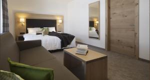 pokój hotelowy z łóżkiem i kanapą w obiekcie Mountain Life w mieście Kappl