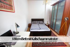 a small bedroom with a bed and a desk at Helles Altbau-Loft mit Kingsize Bett, Smart-TV, etc in Erfurt