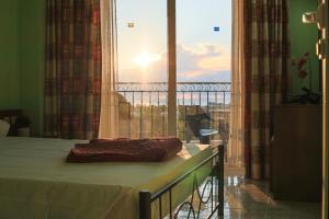 Bett in einem Zimmer mit Blick auf ein Fenster in der Unterkunft Planet View in Faliraki