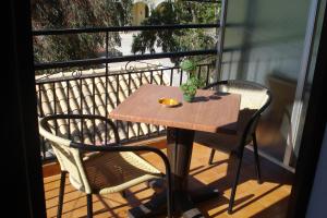 a wooden table and two chairs on a balcony at Smile 2 in Kassiopi