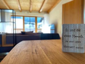 a sign on top of a wooden table at Apartment Bergzauber in Reith im Alpbachtal