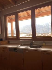 a kitchen with two windows and a sink with a view at Apartment Bergzauber in Reith im Alpbachtal