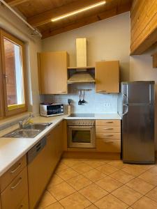 cocina con armarios de madera y nevera de acero inoxidable en Apartment Bergzauber en Reith im Alpbachtal