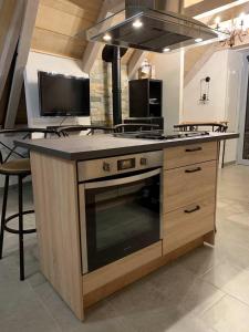 a kitchen with a stove and a counter top at Le Buron des Loups in Soulages-Bonneval