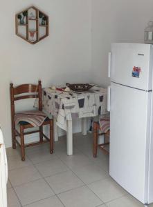 uma cozinha com uma mesa e um frigorífico branco em Panorama Appartment em Agia Marina